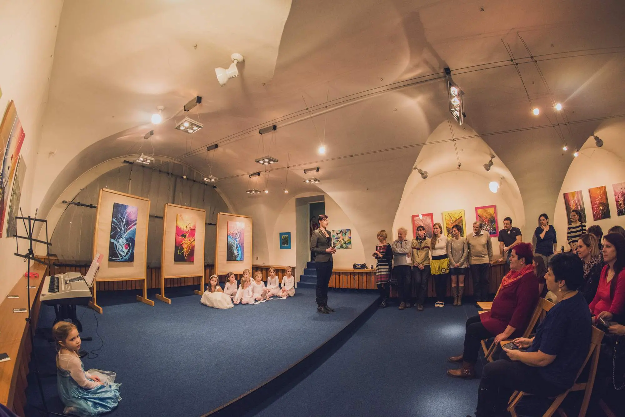 Klenutá galerie s vystavenými abstraktními obrazy
